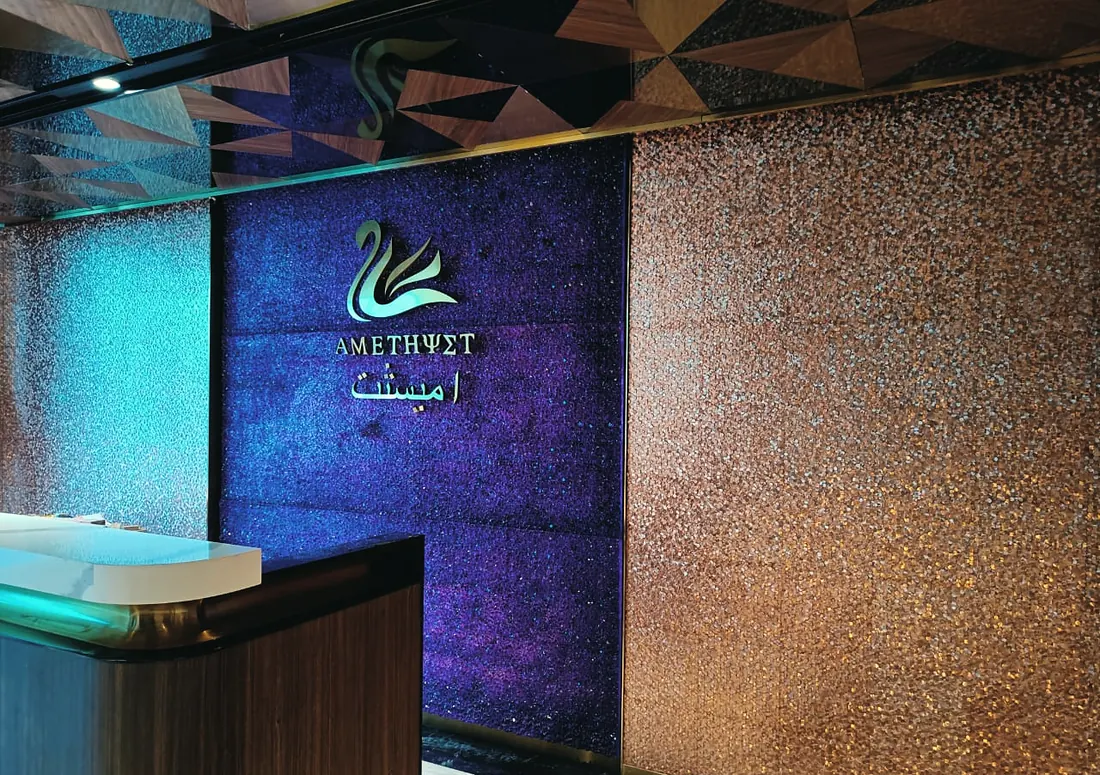 Amethyst Club: backlit sign on a glitter wall at the entrance (frame 3 of 3)