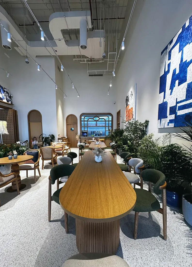 Saya Brasserie: fluted timber table and blue mural in the main room (frame 3 of 3)